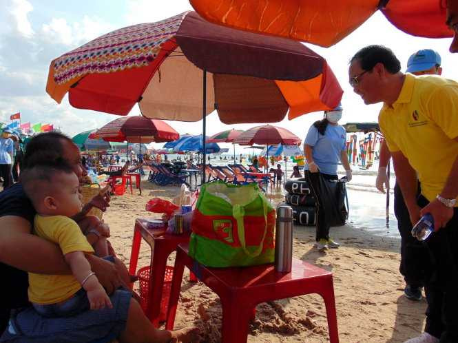 Ông Mai Ngọc Thuận - bí thư Thành ủy Vũng Tàu (áo vàng) - xuống các bãi tắm, đến tận từng bàn du khách vận động không ăn nhậu, xả rác - Ảnh: Đông Hà