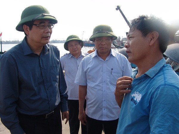 Bộ trưởng Cao Đức Phát cùng lãnh đạo tỉnh Thừa Thiên - Huế lắng nghe ngư dân. Ảnh: Quang Thành