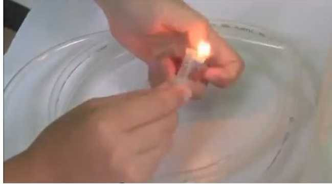 Bước 2: Lấy bật lửa làm nóng ống gen để ống dãn ra sau đó gắn đầu xịt vào.
