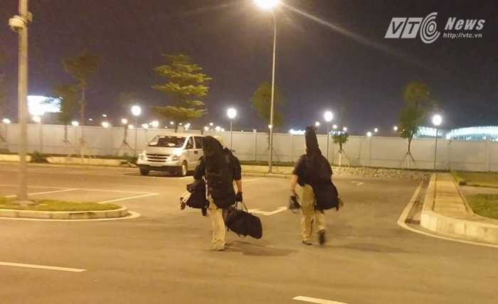 Hai lính bắn tỉa Mỹ rời vị trí về xe sau khi đoàn xe chở ông Obama ra khỏi sân bay - Ảnh: Tùng Đinh