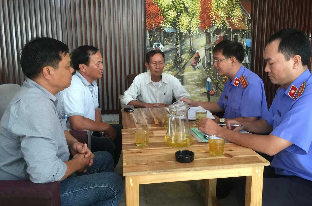 Đại diện VKSND huyện Bình Chánh đang chuẩn bị thủ tục trao quyết định đình chỉ vụ án, đình chỉ bị can với ông Tấn tại quán Xin Chào - Ảnh: Tuổi Trẻ