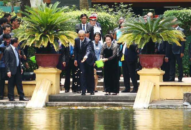 Tổng thống Obama và Chủ tịch Quốc hội Nguyễn Thị Kim Ngân thả thức ăn tại ao cá Bác Hồ - Ảnh: Nguyễn Khánh/ Tuổi trẻ