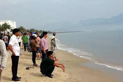 Người dân hiếu kỳ xem cá heo dạt vào bờ.