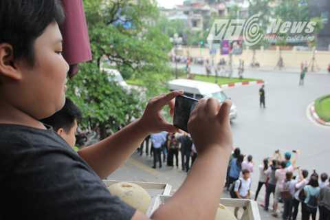 Các phương tiện ghi hình được người dân huy động tối đa nhằm lưu giữ lại khoảnh khắc lịch sử. Chia sẻ với PV VTC News, cậu bé này cho biết đã có mặt ở đây từ rất sớm cùng với bố để được chiêm ngưỡng đoàn xe. 