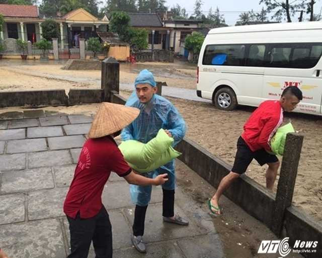 Vận chuyển gạo từ xe vào nhà để trao cho ngư dân.