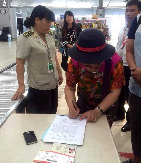 Bà Yan Fengge ký vào biên bản của lực lượng chức năng tại sân bay Cam Ranh, thừa nhận đã trộm điện thoại di động của đồng hương đi cùng chuyến bay - Ảnh: An ninh sân bay Cam Ranh cung cấp