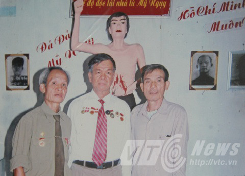 Ông Nghị (ngoài cùng bên phải) trước bức tượng tái hiện hành động đấu tranh năm xưa của mình