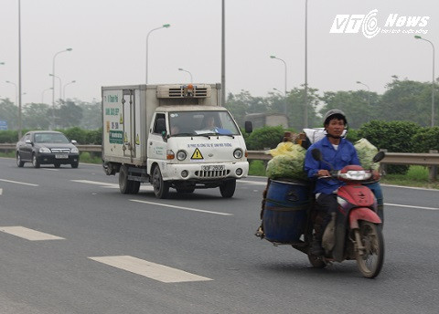 Xe máy chở hàng chen lấn với xe trọng tải rất nguy hiểm