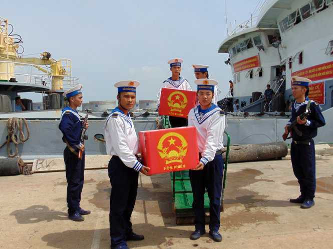 Hai thùng phiếu của hai tàu 624 và 636 được chuyển lên bờ - Ảnh: ĐÔNG HÀ