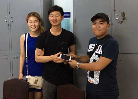 Hiệp sĩ Sin trao lại chiếc điện thoại cho du khách người Hàn Quốc khi bị giật ngoài đường. Ảnh: AS