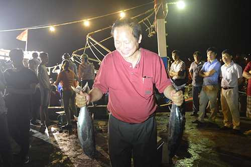 Bộ trưởng Trương Minh Tuấn mua cá ăn tại cảng. Ảnh: Hoàng Táo.