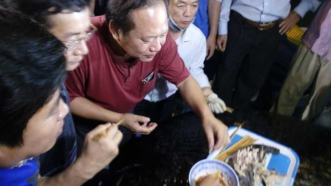 Bộ trưởng Trương Minh Tuấn cùng mọi người dùng cá tươi ngay trên cảng Nhật Lệ
