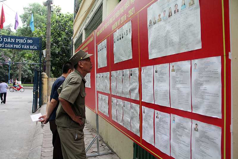 Các cử tri ở phường Nghĩa Đô xem lại tiểu sử các ứng viên trước khi bỏ phiếu 