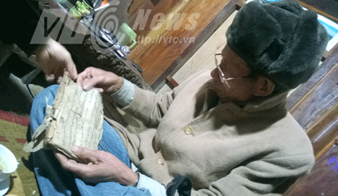 Ông Hà Nam Ninh bên 1 cuốn sách chữ Thái Mường Khoòng cổ