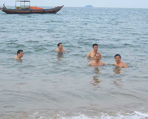 Ông Võ Tá Đinh (hàng đầu tiên, thứ hai từ phải qua) cùng nhiều cán bộ, công chức thuộc Sở Tài nguyên và Môi trường Hà Tĩnh đi tắm biển Thiên Cầm chiều 30/4. Ảnh: Đ.H