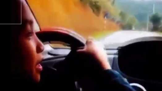 Cháu bé điều khiển xe ở đoạn đường đèo dốc quanh co trong sự cổ vũ của những người lớn ngồi trên xe. 