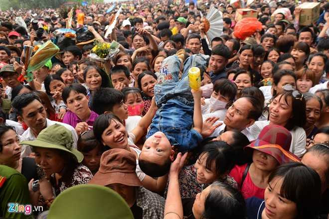 Nhiều em bé phải được công kênh trên đầu để nhiều người chuyền tay nhau đến chỗ lực lượng chức năng (Ảnh: Zing)
