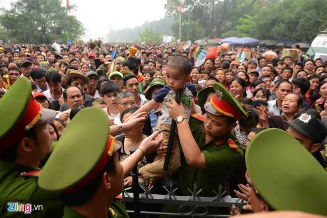 Hàng trăm trẻ nhỏ được các chiến sĩ công an hỗ trợ bồng bế qua hàng rào, đưa lên khu y tế, chờ đợi cha mẹ đón (Ảnh: Zing)