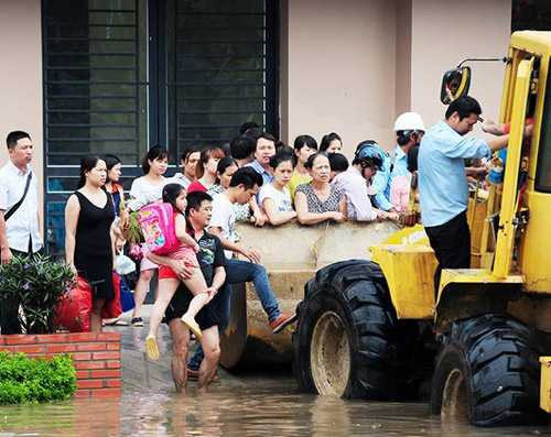 Hàng chục người phải tranh giành nhau từng chỗ đứng trên chiếc máy xúc để đến cơ quan sớm nhất. Ảnh Khám Phá