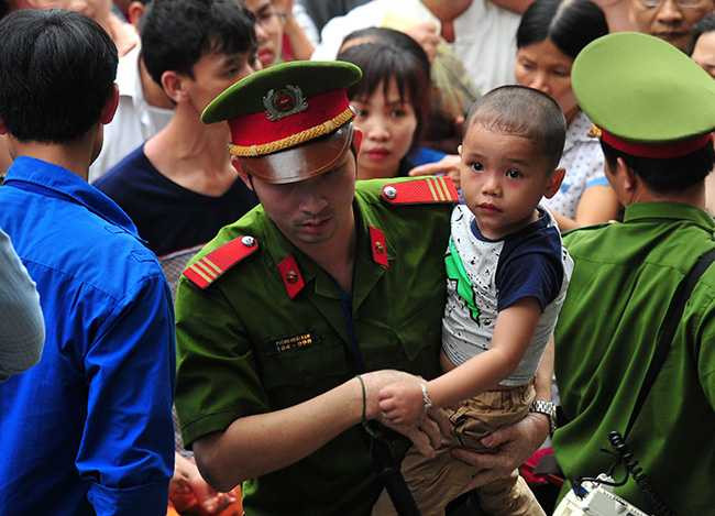 Nhiều em nhỏ bị ngạt thở được lực lượng chức năng đưa tới nơi thoáng mát hơn.