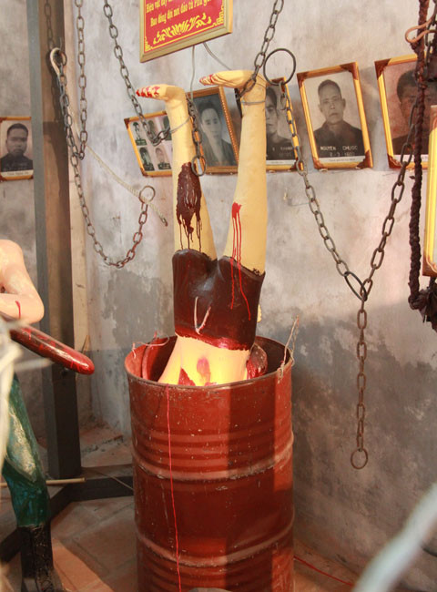 Dốc đầu tù binh vào thùng phuy rồi gõ vào thùng