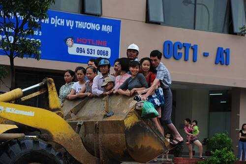 Tại một tuyến phố khác nhiều người dân cũng phải nhờ đến chiếc máy cẩu để di chuyển do phố đã ngập nước Ảnh otofun. 