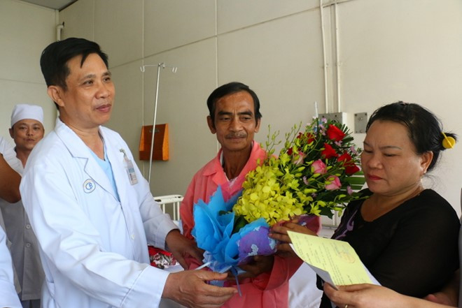 Lãnh đạo Bệnh viện Chợ Rẫy tặng hoa chúc mừng ông Nén được xuất viện. Ảnh: Bệnh viện cung cấp.