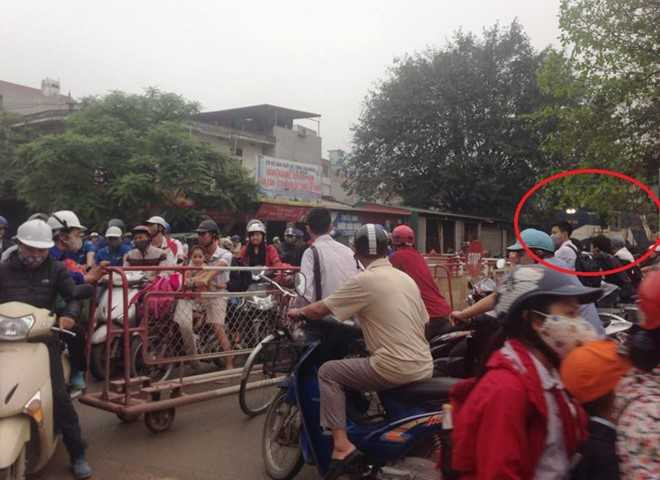 Đoàn tàu chở hàng buộc phải dừng từ xa khi hàng chục người điều khiển xe máy vượt rào chắn băng đường ray trên quốc lộ 21B sáng 13/4. Ảnh: Lê Anh Tú.