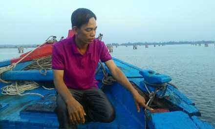 Ông Nguyễn Thương và vết nứt bên mạn tàu do bị đâm. Ảnh: N.Tiến.