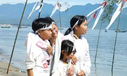 Mẹ và con nạn nhân xấu số tại lễ cầu siêu cho linh hồn các nạn nhân xấu số 10 năm trước. Ảnh T.Tuấn.