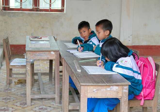 Vì mỗi lớp có 3 học sinh nên bàn ghế được bố trí đơn sơ, cô giáo cũng sắp xếp chỗ ngồi của mình ngay cạnh các em để tiện dạy dỗ.