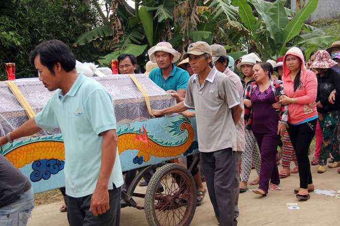 Chị Đặng Mai Thi, mẹ em Trịnh Hữu Nhân đi sau quan tài con trai và phải nhờ đến hai người dìu đi. (Ảnh: Tuổi Trẻ).