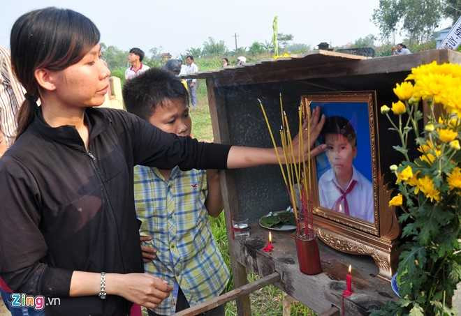 Chị Nguyễn Thị Minh Khai vuốt tay lên di ảnh trước khi giã biệt em trai Nguyễn Minh Hoàng. (Ảnh: Zing.vn).