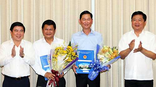 Bí thư Thành ủy TP HCM Đinh La Thăng, Chủ tịch UBND TP HCM trao quyết định và hoa chúc mừng cho 2 tân Phó chủ tịch UBND thành phố Huỳnh Cách Mạng và Trần Vĩnh Tuyến. Ảnh: P.Đ