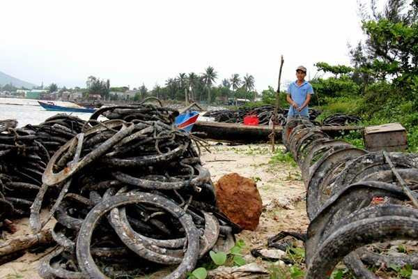 Lốp cao su cũ được người dân kết từng chuỗi rồi thả xuống đầm Lập An.