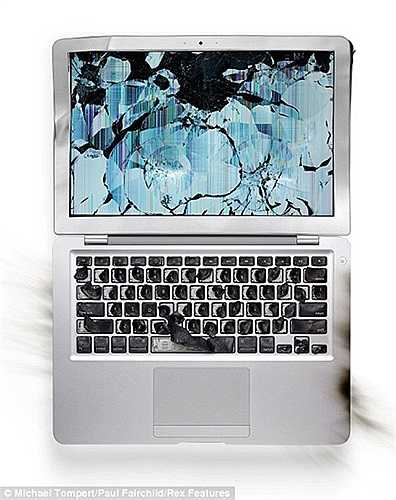 Màn hình LCD của chiếc MacBook Air bị đập vỡ một cách nghệ thuật bằng một chiếc búa trong khi bàn phím bị đốt cháy đen thui.