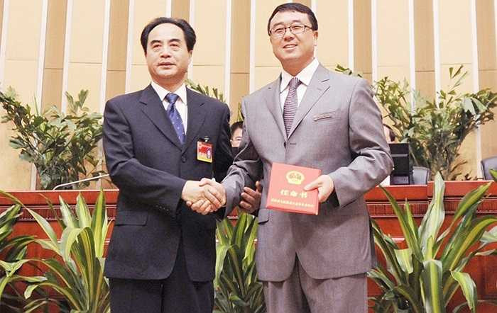 Người hùng chống xã hội đen Vương Lập quân được bầu giữ chức Phó Thị trưởng Trùng Khánh chụp ảnh lưu niệm và nhận giấy chuyển công tác với Chủ tịch ủy ban thường vụ Trùng Khánh, ông Trần Quang Quốc