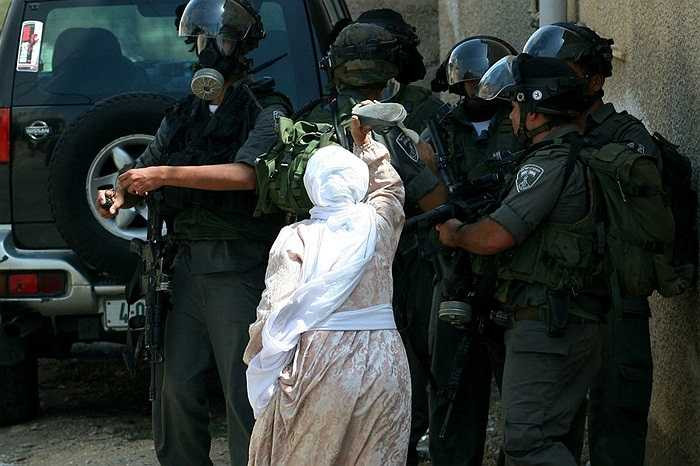 Người phụ nữ Palestine giận dữ dùng giày đe dọa binh lính Israel trong cuộc xung đột chiếm đất ở ngôi làng Kafr Qaddum, gần thành phố Bablus,khu Bờ Tây.