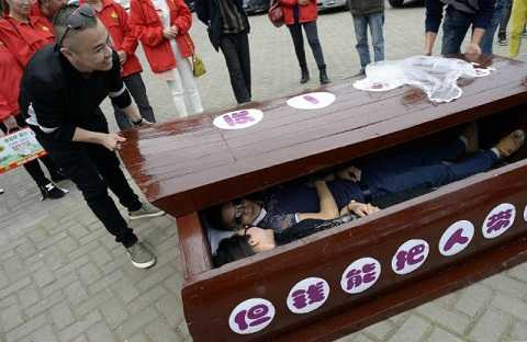 Người tham gia trò chơi sẽ nằm cùng một người khác trong chiếc quan tài đậy kín nắp. Ảnh NetEase