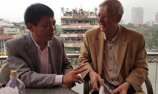 Nhà văn Đặng Vương Hưng tặng hoa ông Carl W. Greifzu (bên phải) và hai người thân mật trò chuyện