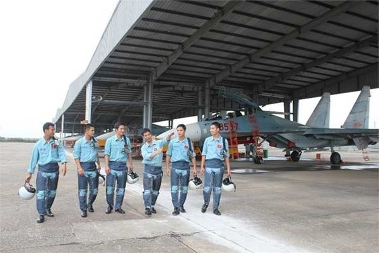 Đại úy phi công Đặng Đức Công (thứ ba từ phải sang), biên đội trưởng đang chia sẻ kinh nghiệm bay với các phi công trẻ sau chuyến bay làm nhiệm vụ. 