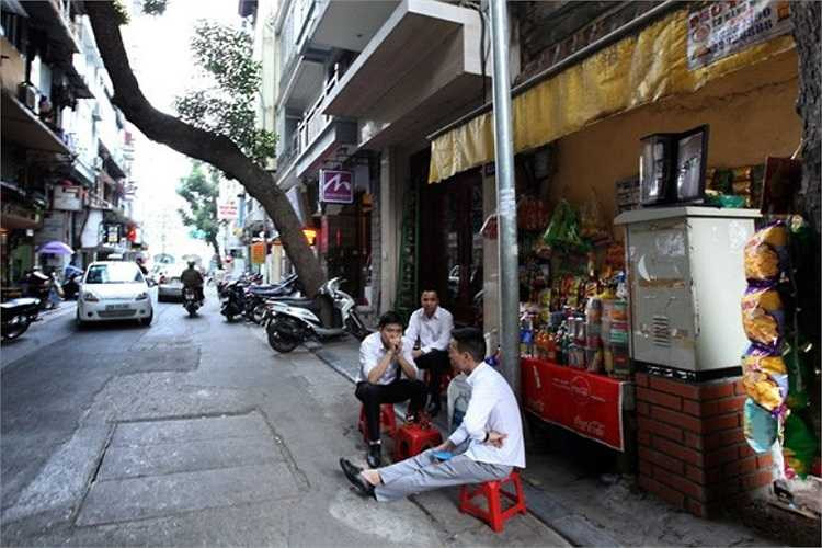 Quán giải khát quây kín một hộp điện trên phố Hàng Hành.