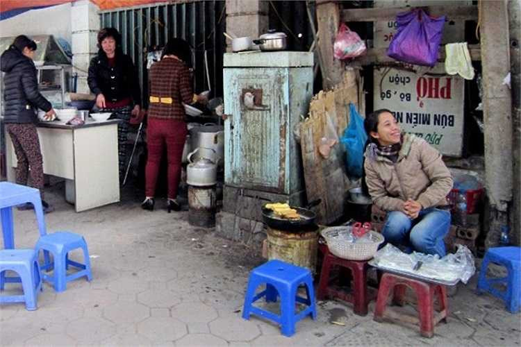 Bếp than tổ ong, xoong nồi của quán ăn trên vỉa hè phố Trần Hưng Đạo quây quanh hộp điện.