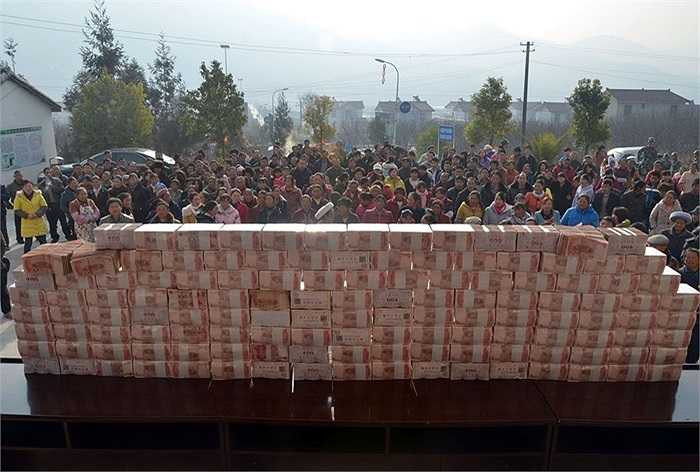 Tiền mặt thưởng Tết cho người làng giàu nhất Trung Quốc được xếp ngay ngắn thành hàng dài 2m