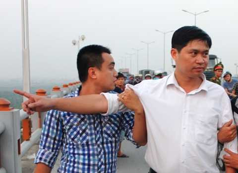 Thủ phạm Nguyễn Manh Tường (áo trắng) chỉ nơi ném thi thể chị Huyền xuống sông Hồng tại khu vực cầu Thanh Trì.