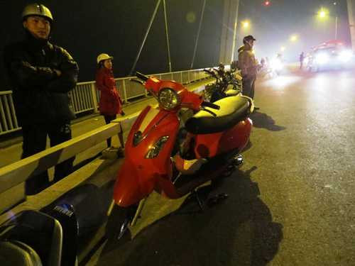 Chiếc xe tay ga của người phụ nữ để lại trên cầu cùng đôi giầy. Ảnh: Trường Giang