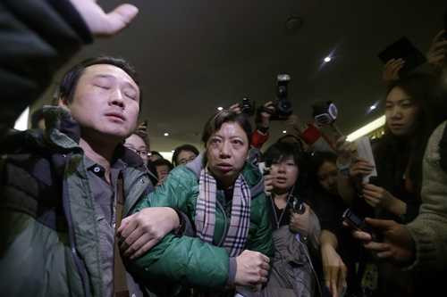 A woman, whose husband is a passenger of Malaysia Airlines flight MH370, attempts to leave a hotel after complaining about Malaysia Airlines, in Beijing March 8, 2014.