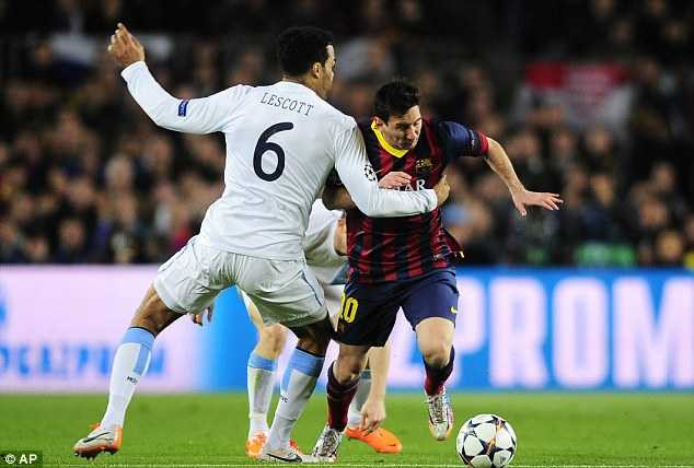 Bring him down: Messi is grabbed by Manchester City's Joleon Lescott