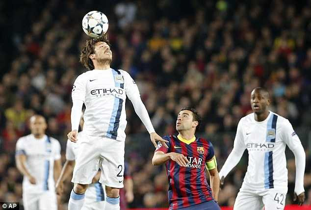 Aerial: David Silva gets up to head the ball on for City as Xavi keeps close guard