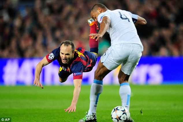 Mine: Vincent Kompany takes the ball from Andres Iniesta's feet in midfield